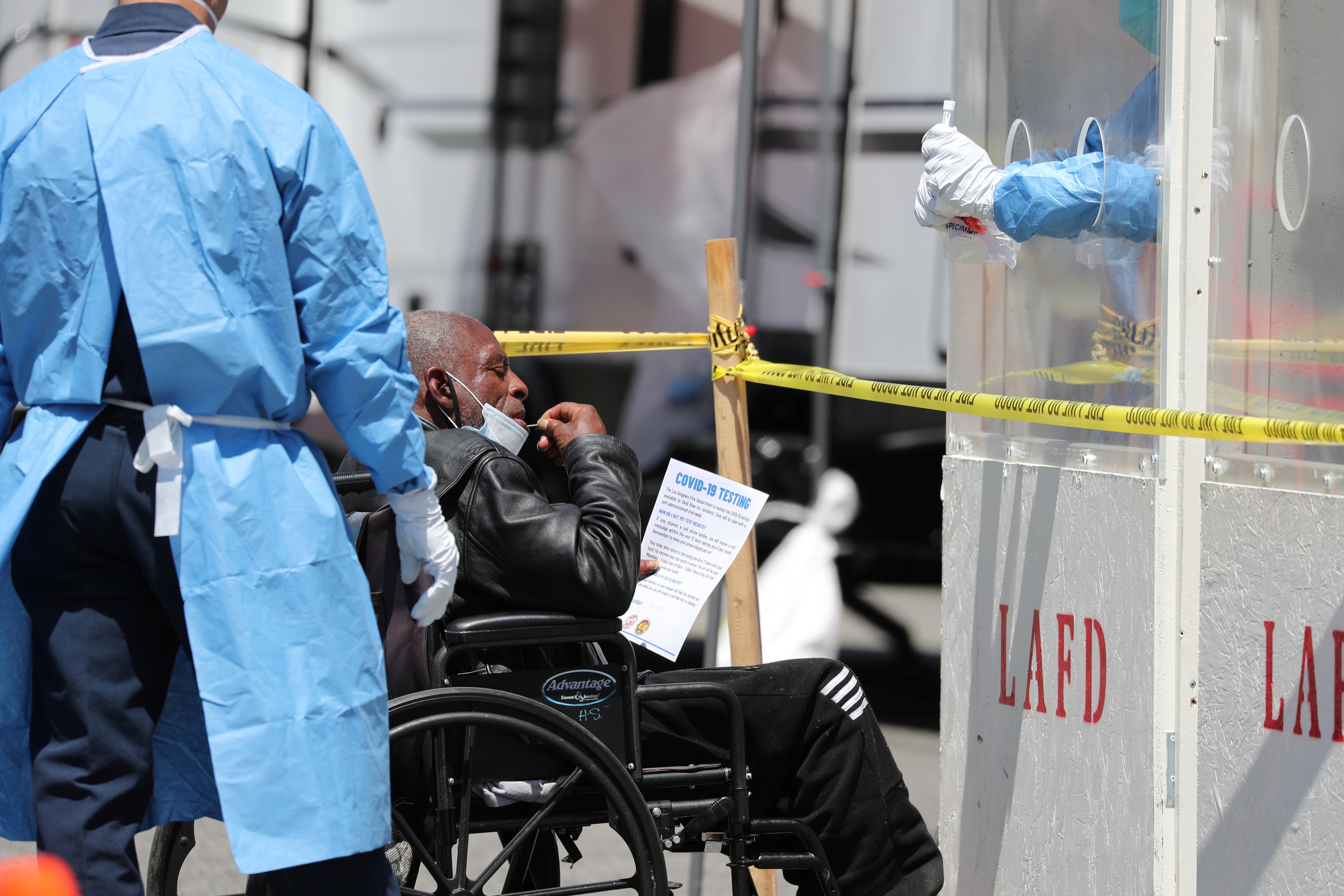 A man is tested for coronavirus disease (COVID-19) at a Los Angeles fire department testing station for the homeless on Skid Row, Los Angeles, California, where the virus is highlighting stark inequality