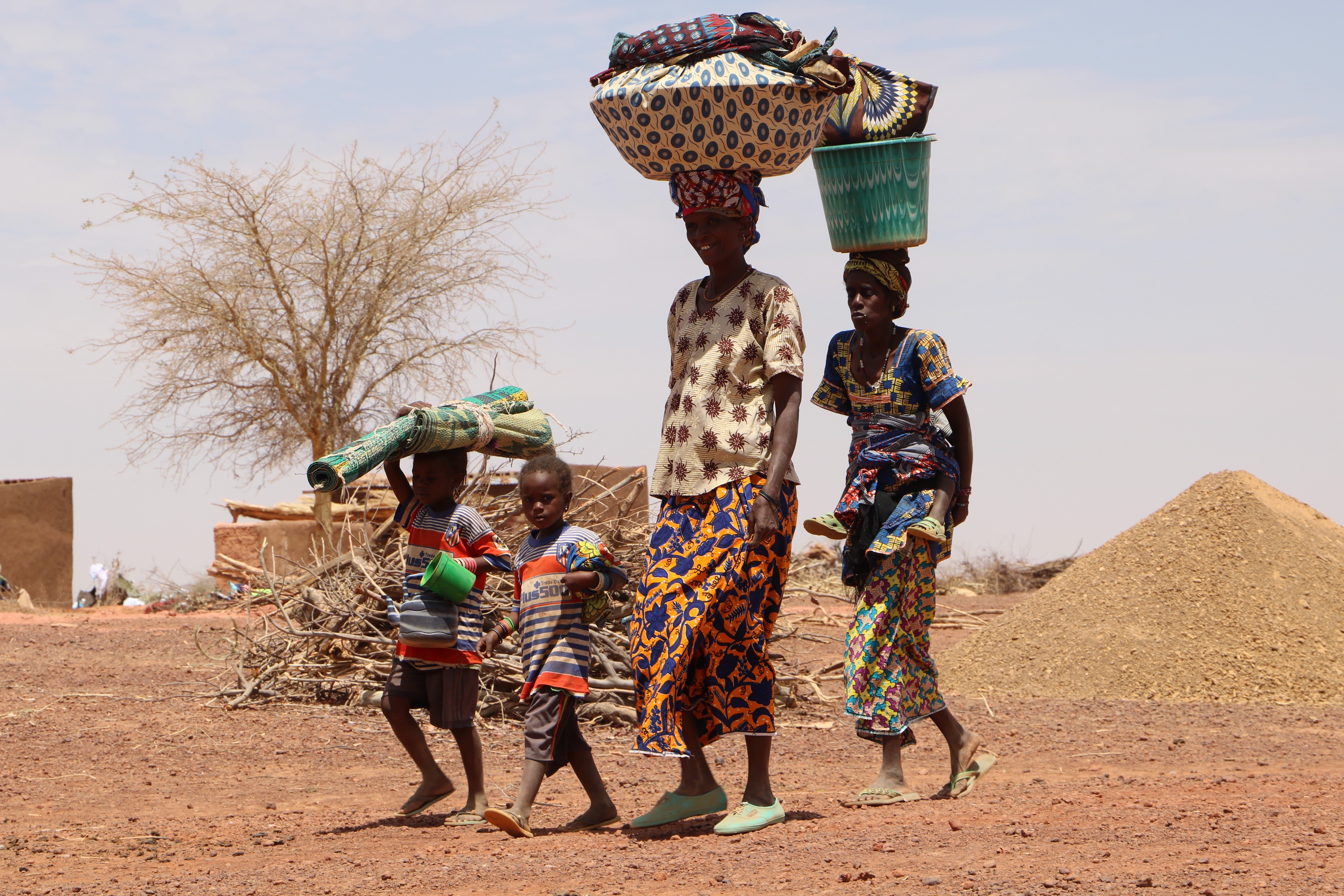 Women who were displaced from home when gunmen attacked their village walk to a makeshift displacement site in Yatenga province