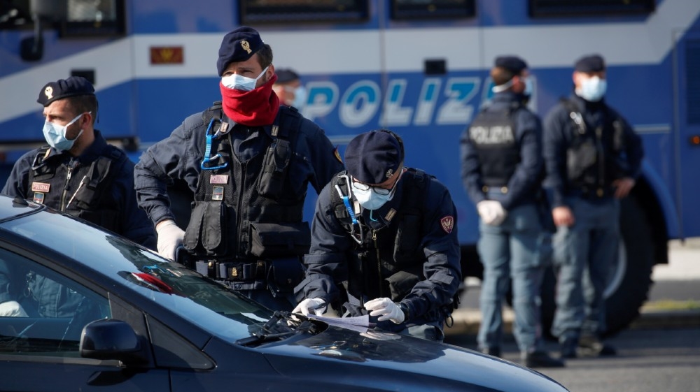 FILE PHOTO: Police officers wearing protective face masks check documents of drivers, during the coronavirus disease (COVID-19) outbreak in Ostia, near Rome, Italy April 13, 2020.