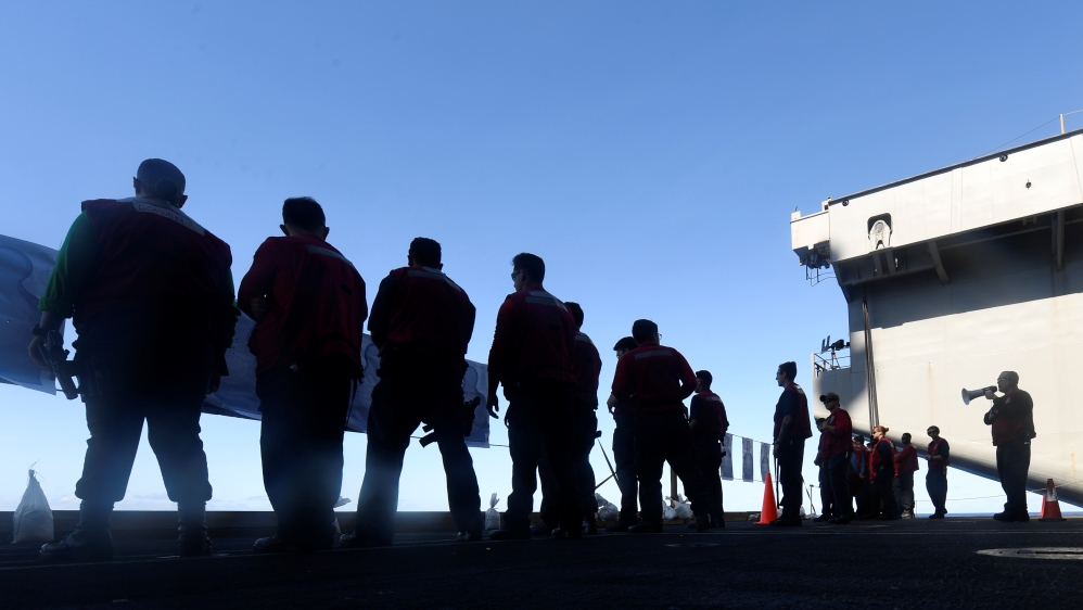 US Navy sailors participate in a small arms qualification on board the aircraft carrier USS Theodore Roosevelt in the Philippine Sea