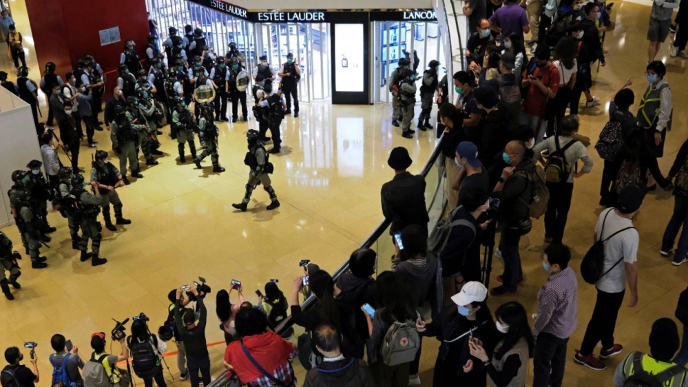 Police watch the dispersal of anti-government protesters from a shopping mall after a rally in Hong Kong on Sunday