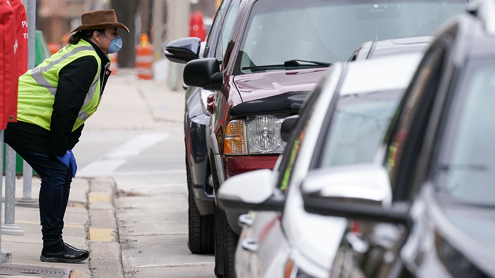 Jill Mickelson helps a drive-up voter outside the Frank P Zeidler Municipal Building in Milwaukee, Wisconsin. The city is now allowing drive-up early voting for the state’s April 7 election.