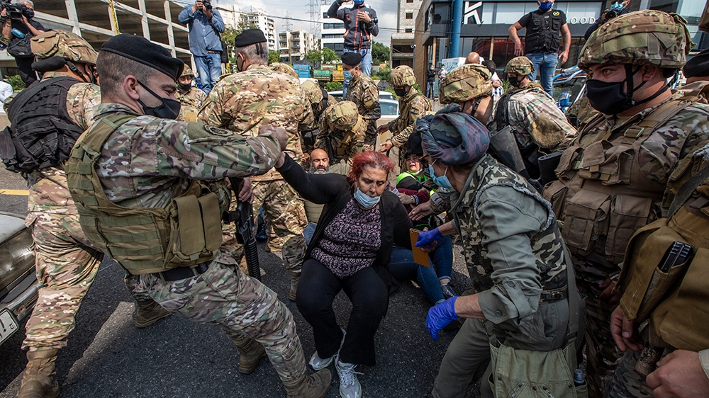 Soldiers attempt to open the northern highway during protests against the collapsing Lebanese pound
