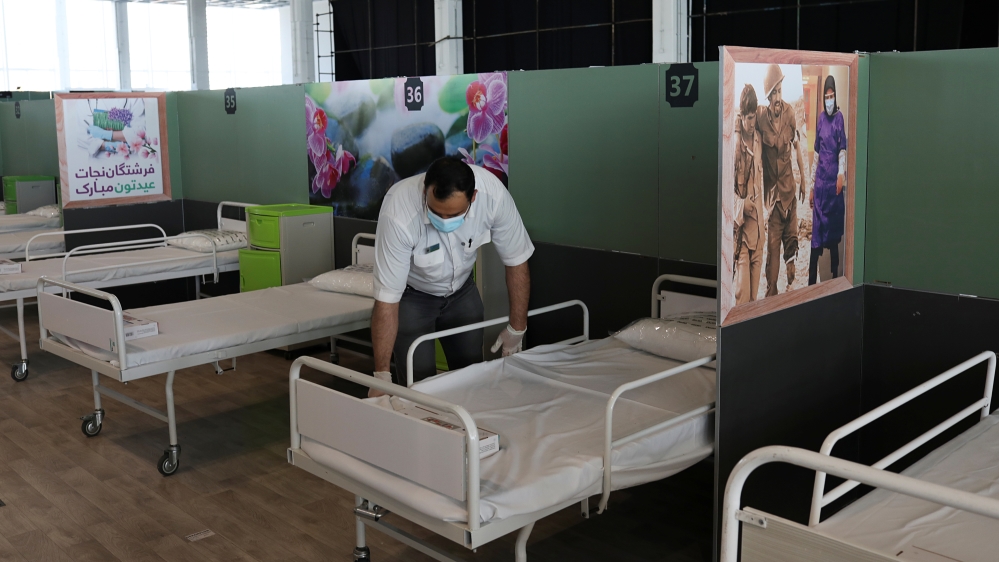 A medical aid worker sets up and installs a bed at a shopping mall,  to receive patients suffering from the coronavirus disease (COVID-19), in Tehran