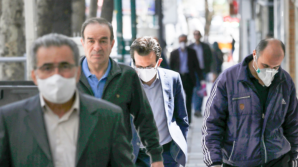 People wearing face masks to protect against the new coronavirus walk on a sidewalk in northern Tehran, Iran, Saturday, April 4, 2020. In the first working day after Iranian New Year holidays authorit
