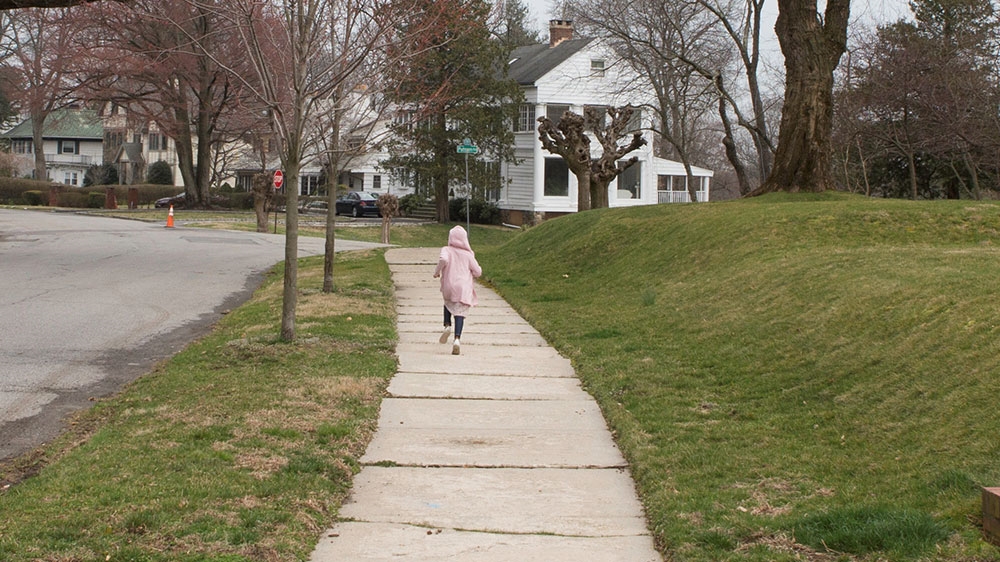 A young girl runs on a deserted street inside an area under lockdown due to coronavirus disease