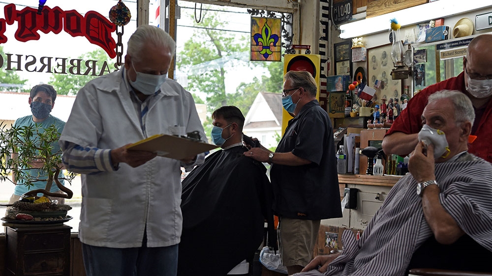 Men receive haircuts as social-distancing guidelines to curb the spread of COVID-19 are relaxed at Doug’s Barber Shop in Houston, Texas