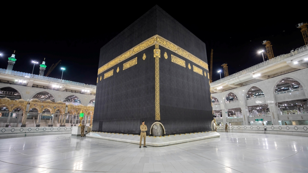 Saudi security officers stand in front of the Kaaba in an empty Grand Mosque, as a preventive measure against the coronavirus disease (COVID-19), during the holy month of Ramadan,