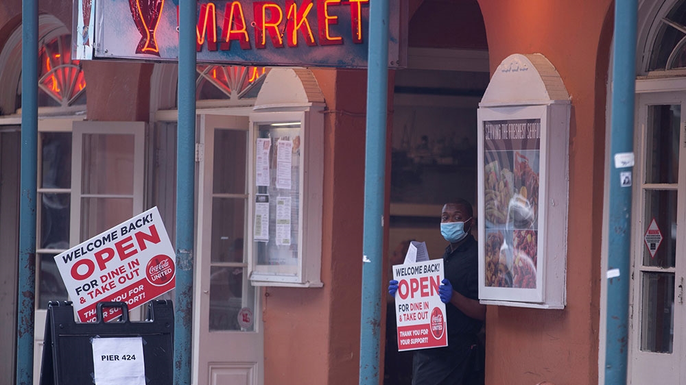 A worker stands outside Pier 424 Seafood Market as coronavirus lockdown restrictions were eased after two months, including allowing for 25 percent of permitted occupancy in stores and restaurants in New Orleans, Louisiana