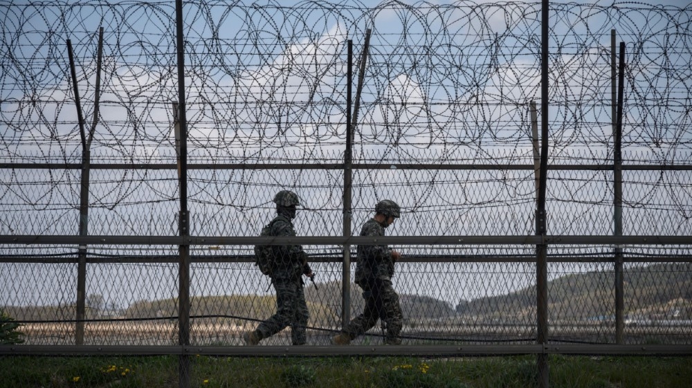 South Korean soldiers patrol along a barbed wire fence Demilitarized Zone (DMZ) separating North and South Korea, on the South Korean island of Ganghwa on April 23, 2020.