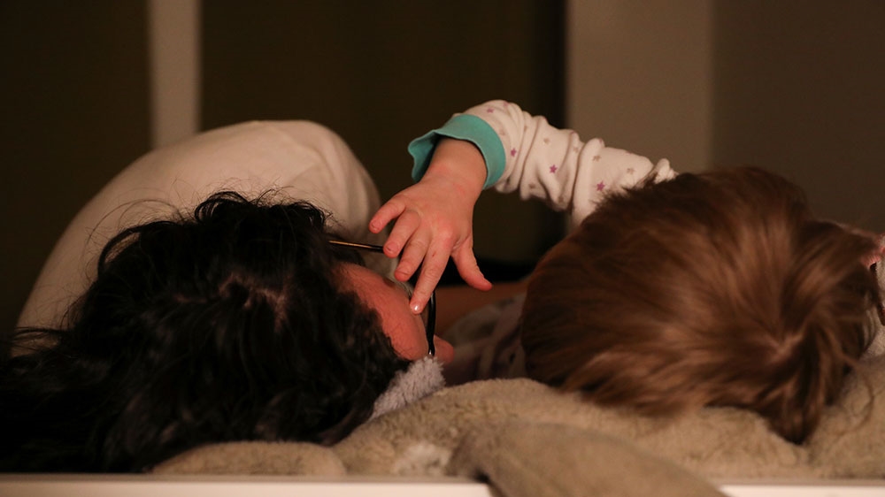 A woman puts her son to bed during the outbreak of coronavirus disease