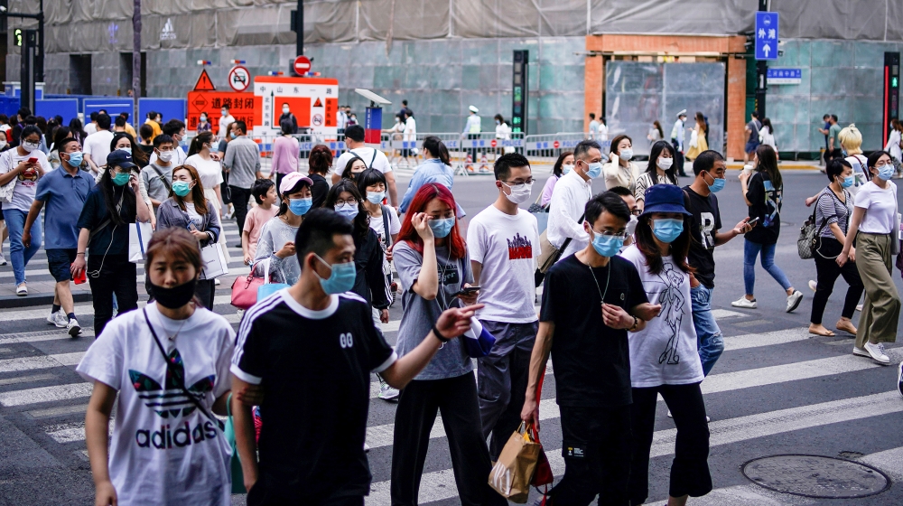 People wearing protective face masks are seen on a street following an outbreak of the novel coronavirus disease (COVID-19), in Shanghai, China May 25, 2020. REUTERS/Aly Song