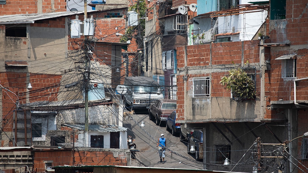 A man walks wearing a face mask to prevent the spread of the coronavirus walks on a street at a slum in Caracas, Venezuela