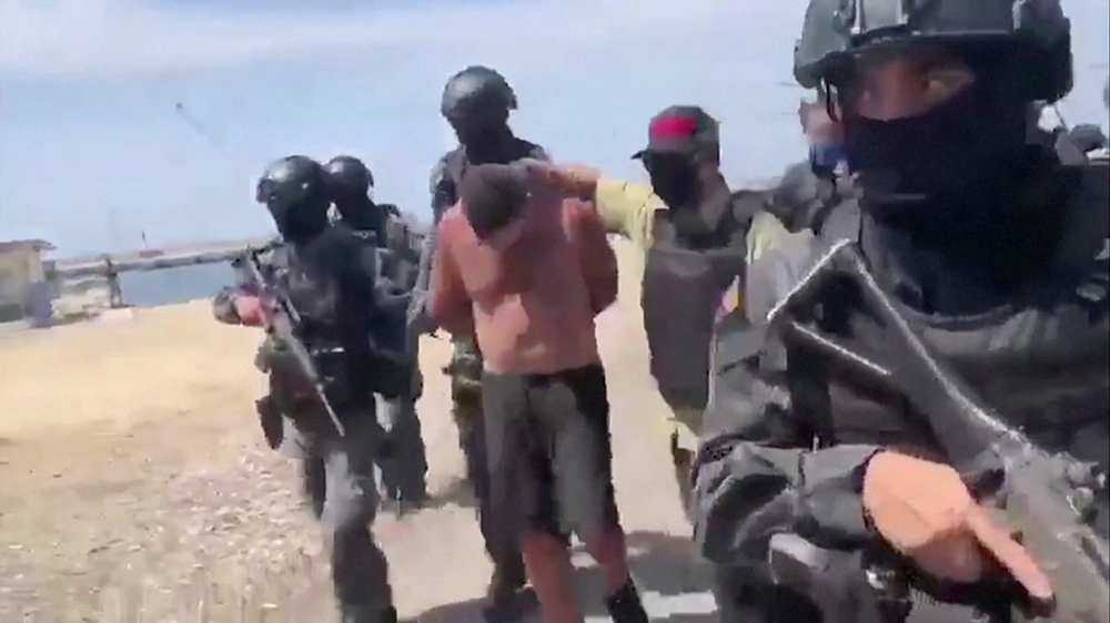 Venezuelan soldiers in balaclavas move a suspect from a helicopter after what Venezuelan authorities described was a 