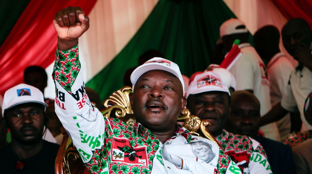 Burundi’s incumbent president Pierre Nkurunziza raises his fist as he reacts to supporters during the last campaign rally of the candidate of the ruling party the National Council for the Defense of D