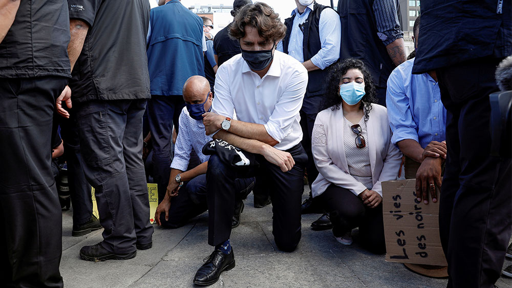 Canada’s Prime Minister Justin Trudeau wears a mask as he takes a knee during a rally on Parliament Hill, in Ottawa, Ontario to protest against the death in Minneapolis police custody of George Floyd