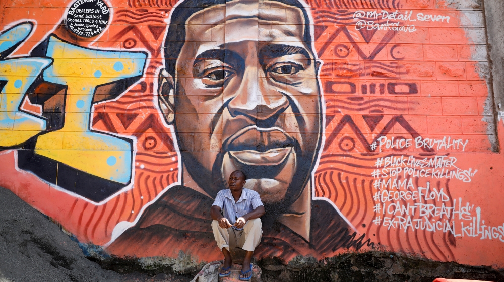 A man sits under a graffiti depicting African-American man George Floyd, who died in Minneapolis police custody, at the Kibera slum of Nairobi, Kenya, June 4,2020.REUTERS/Baz Ratner TPX IMAGES OF THE