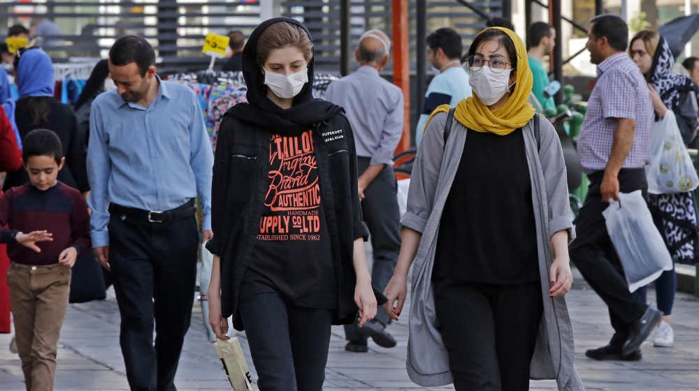 Iranians, some wearing face masks, walk along a street in the capital Tehran on June 3, 2020, amid the novel coronavirus pandemic crisis. - The spread of novel coronavirus has accelerated again this m