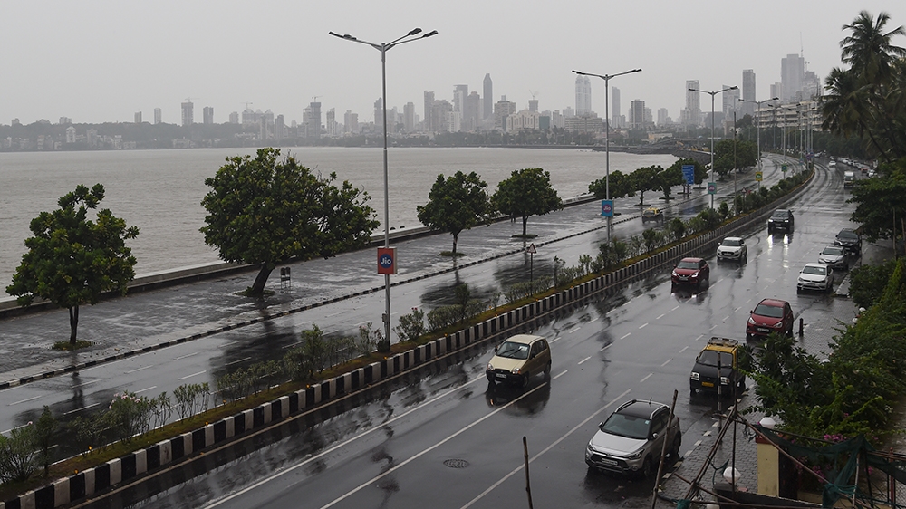 Commuters drive along Marine Drive as rain falls in Mumbai on June 3, 2020 as cyclone Nisarga barrels towards India''s western coast. - Mumbai authorities shut offices, banned small gatherings and told