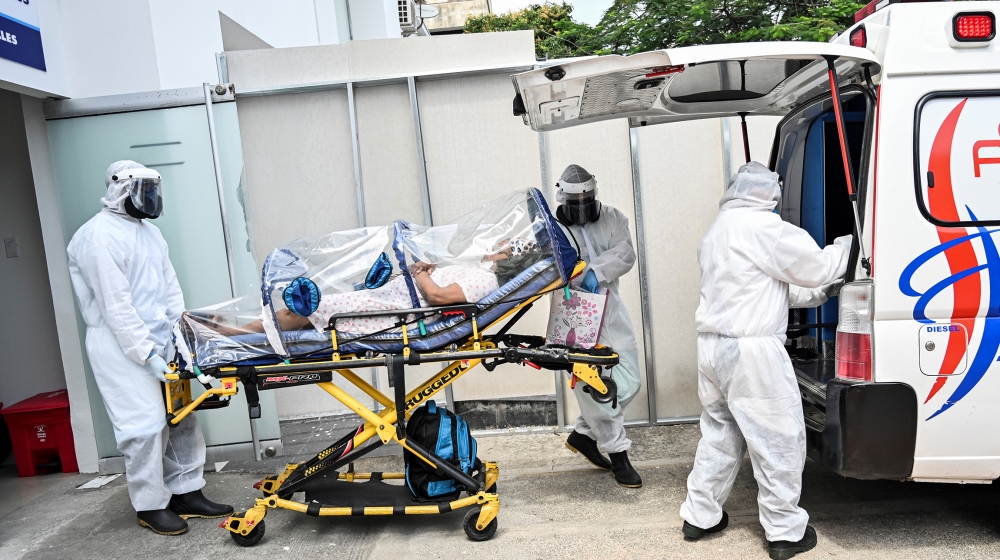 Health workers move a recovered novel coronavirus patient from the Versalles clinic to her home on June 24, 2020, in Cali, Colombia. Colombia extended its quarantine Tuesday until July 15, as its COVI