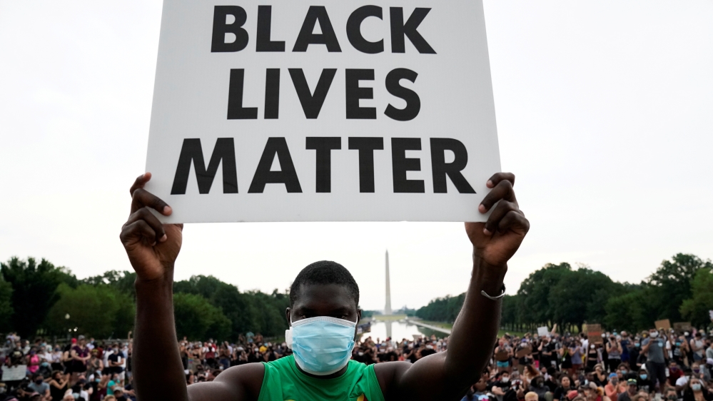 A person holds a placard as demonstrators gather at the Lincoln Memorial during a protest against the death of George Floyd in Washington, DC