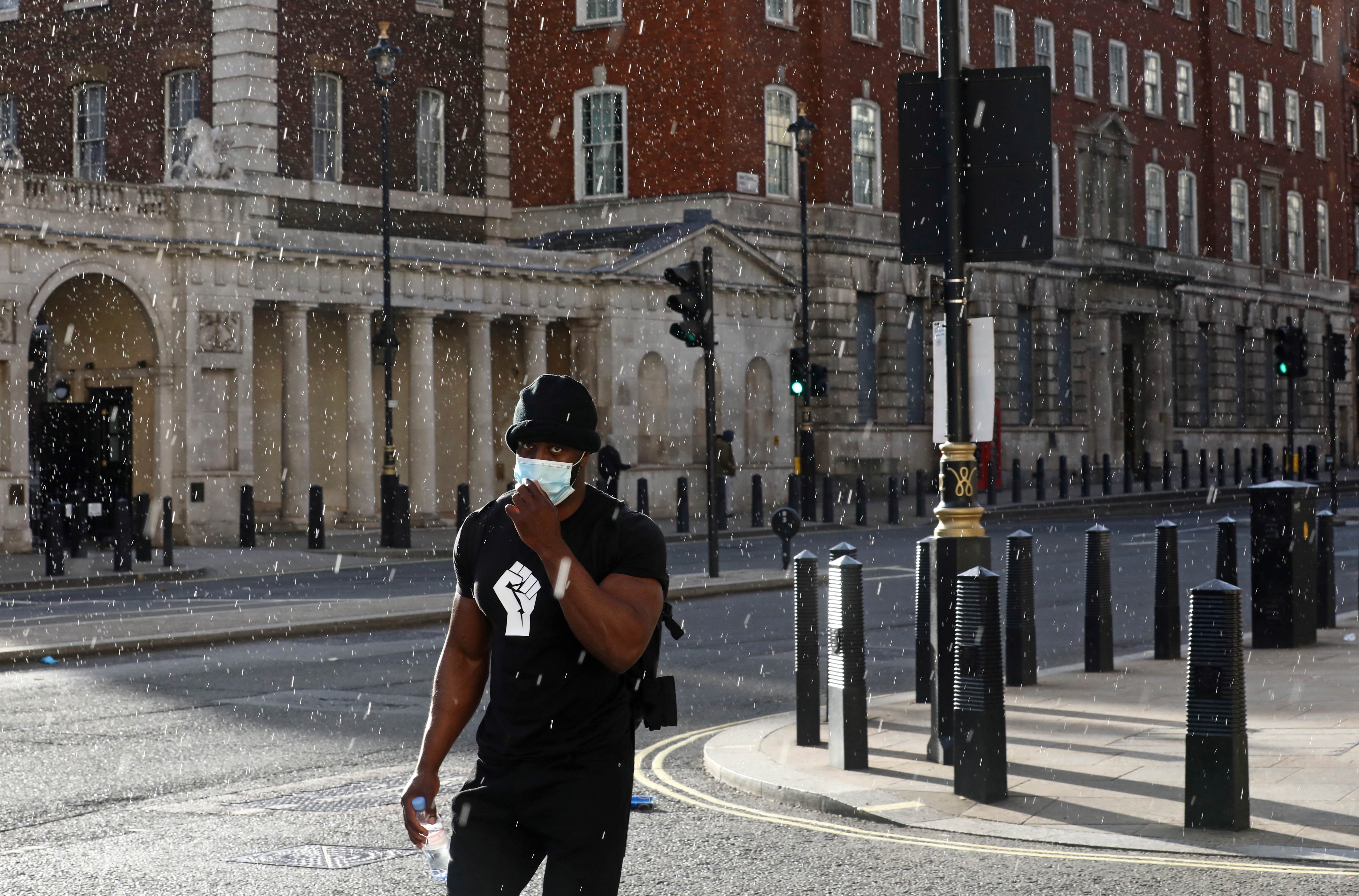 A man wears a t-shirt with a raised fist during a Black Lives Matter protest in London, UK