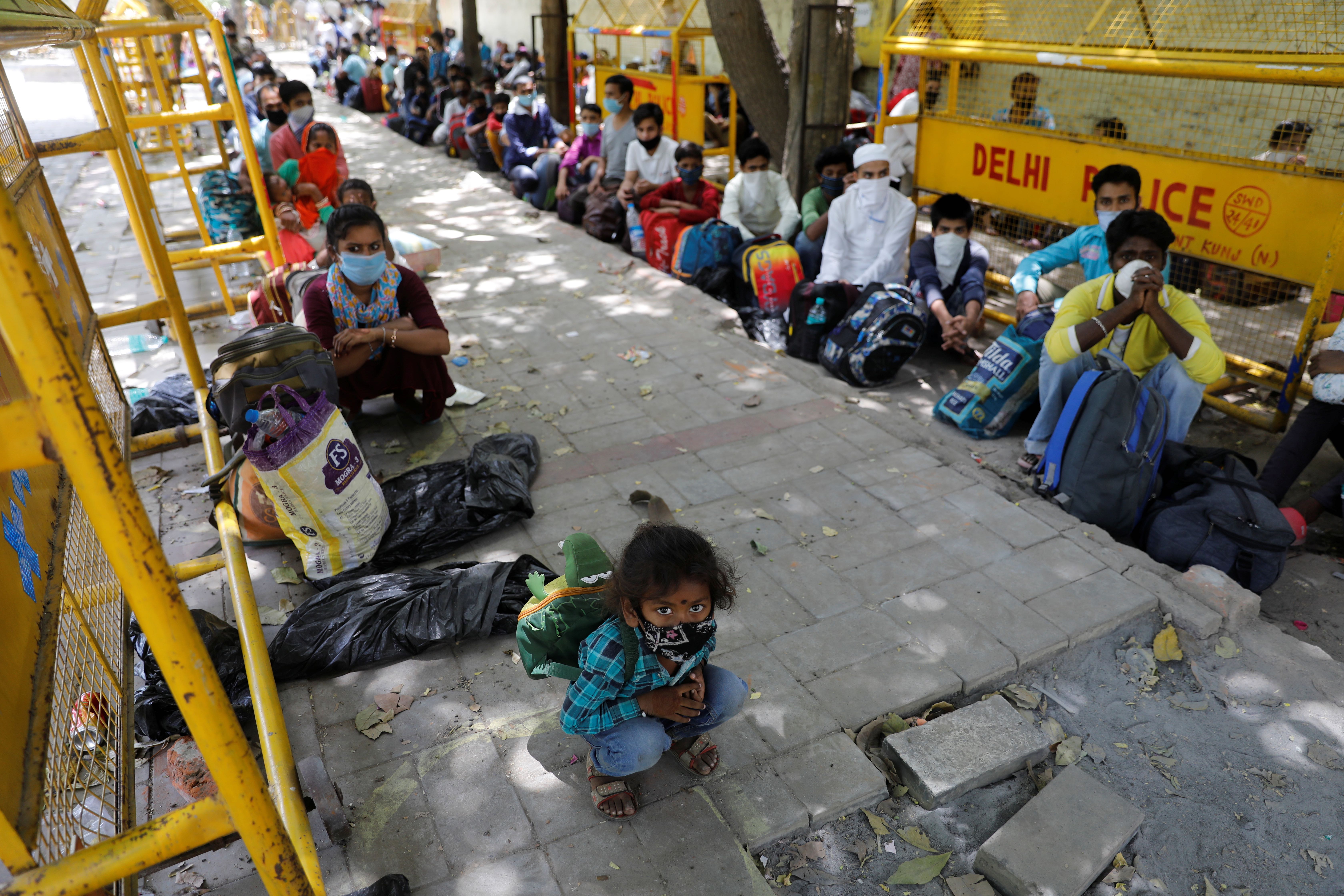 Migrant workers wait for a bus during an extended coronavirus lockdown in New Delhi, India