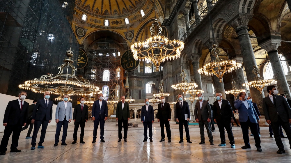 This handout picture released by the Turkish Presidential press office shows Turkish President Tayyip Erdogan (C), flanked by Turkish Culture and Tourism Minister Mehmet Nuri Ersoy (C-L) and the head