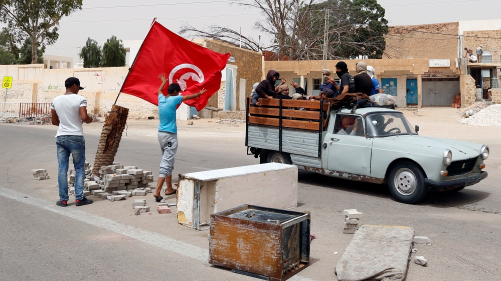 Protesters, who are demanding jobs and a share in revenue from the area''s natural resources, react as they block the road which is usually used by foreign oil companies to go the oilfield in Tatouine