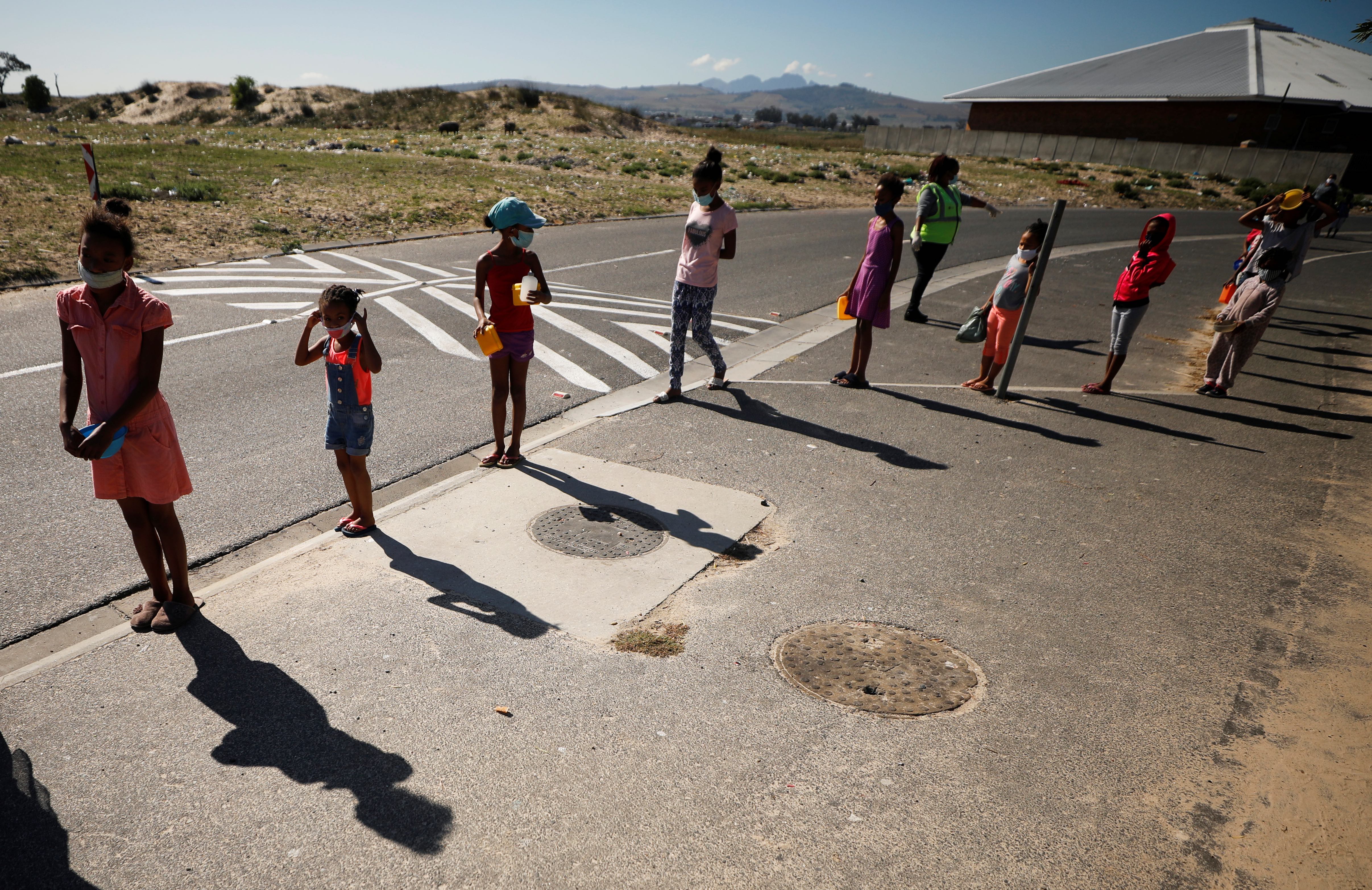 Children queue for food at a school in Blue Downs township near Cape Town, South Africa