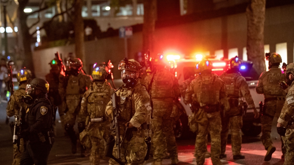 Federal law enforcement officers close a street downtown as they move towards protesters during a demonstration against police violence and racial inequality in Portland, Oregon, US