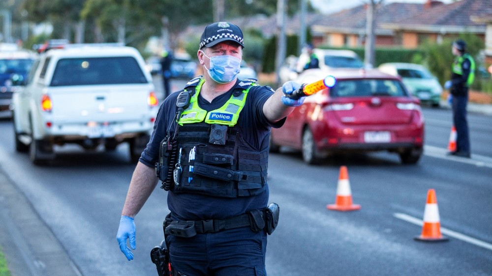 Police stop drivers at a checkpoint as coronavirus disease cases spike in Melbourne
