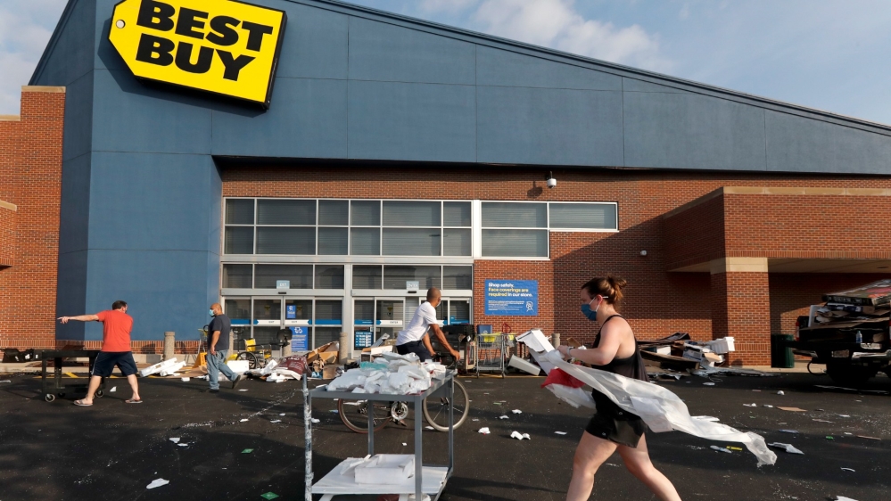 Volunteers help clean up the car park outside a Best Buy store in Chicago after some broke into the store overnight