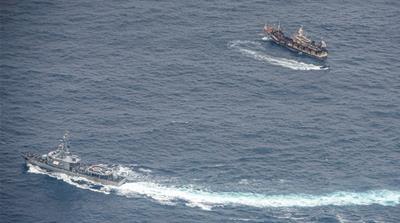 Ecuadorian Navy vessels surround a fishing boat after detecting a fishing fleet of mostly Chinese-flagged ships in an international corridor that borders the Galapagos Islands’ exclusive economic zone, in the Pacific Ocean, August 7, 2020 [File: Santiago Arcos [Reuters]