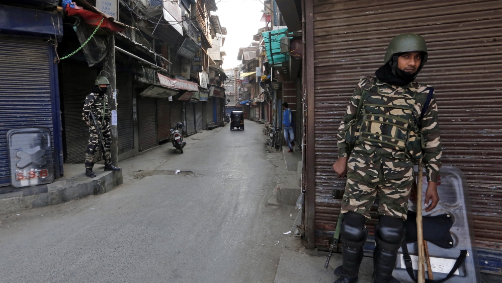 Indian security force personnel stand guard i