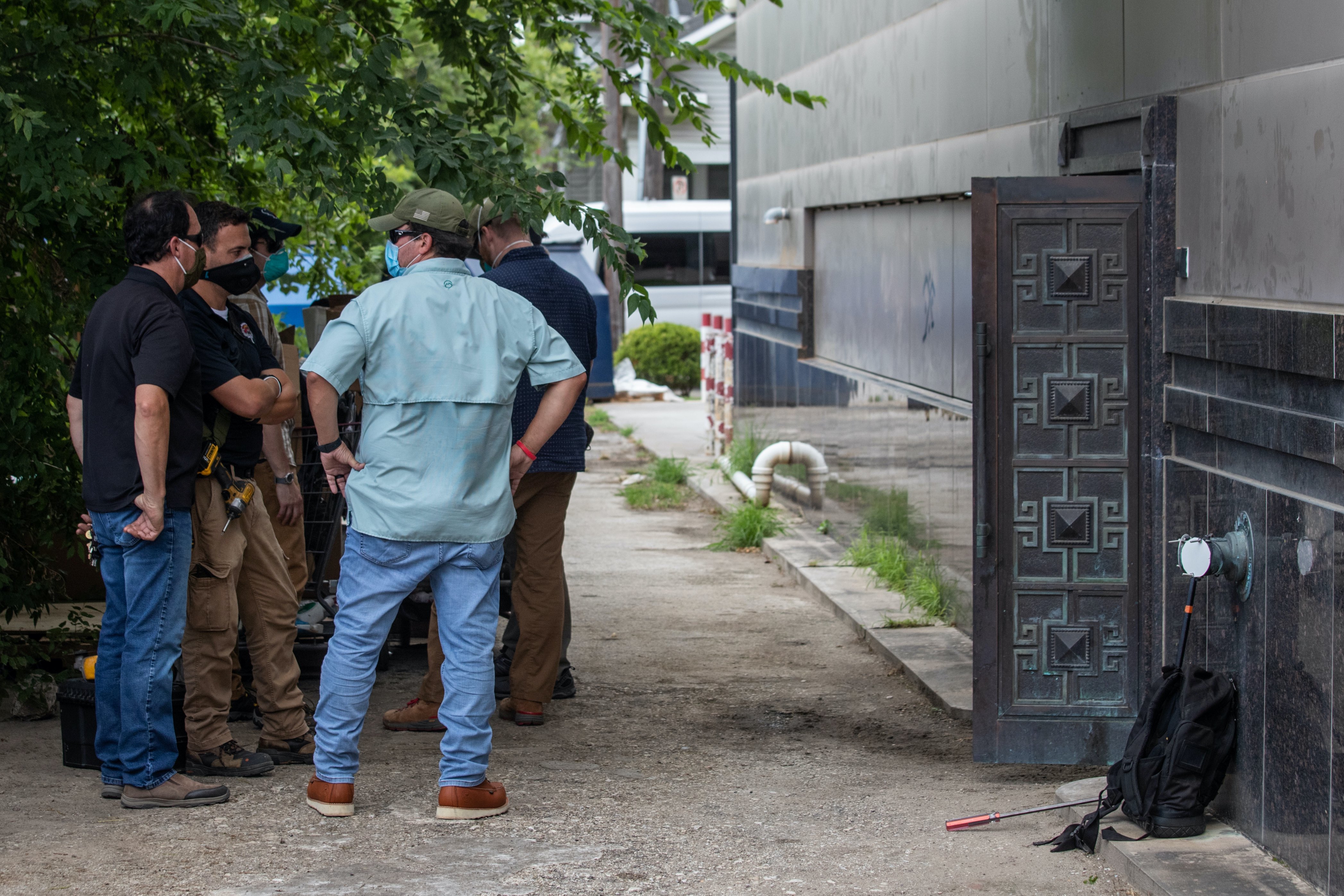 Plain-clothes US security officials stand outside the back door of China’s Consulate after Chinese employees left the building, in Houston, Texas, United States