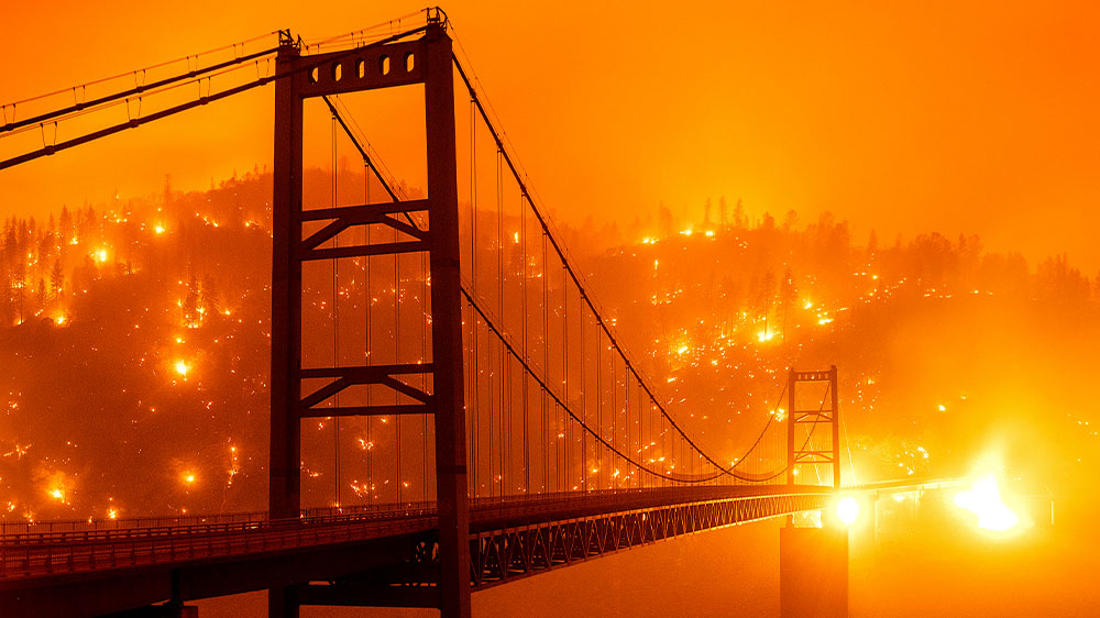 Fire embers light up a hillside behind the Bidwell Bar Bridge as the Bear Fire burns in Oroville, California. The blaze was part of the lightning-sparked North Complex fire, one of dozens of regional fires spread by high winds
