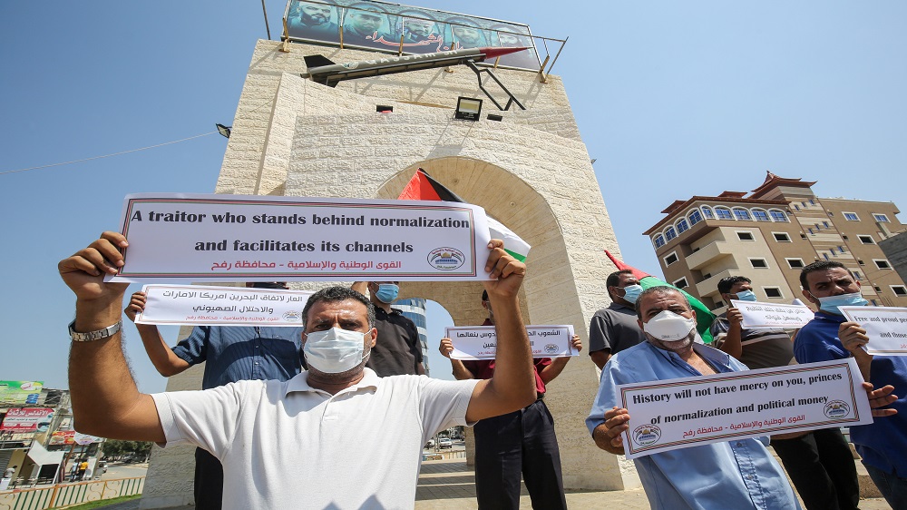 Palestinians carry placards during a protest in Rafah in the southern Gaza Strip on Saturday