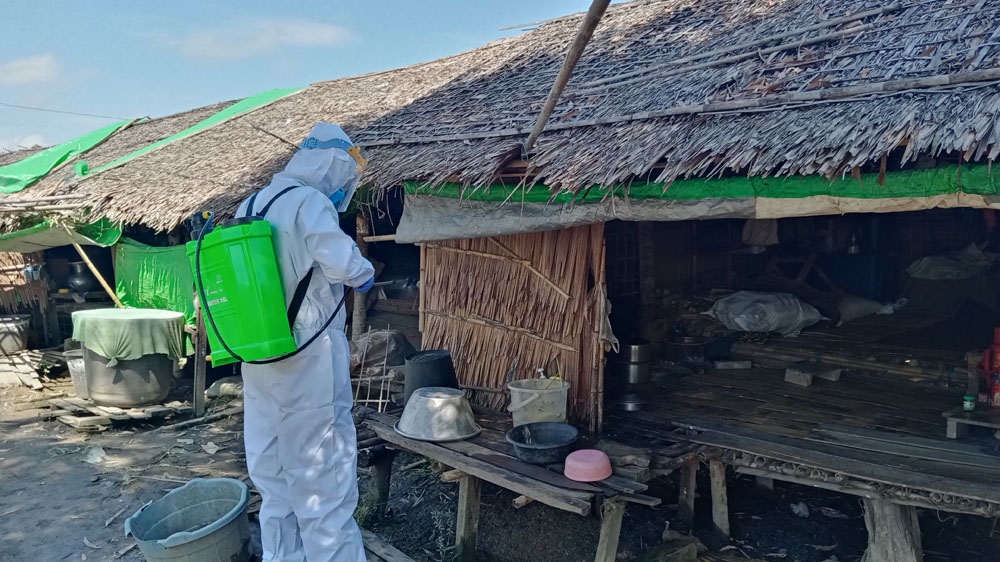 A volunteer sprays disinfectant in Tain Nyo, a camp for internally displaced persons, in Mrauk-U township in Rakhine State earlier this month [Supplied/[Al Jazeera]