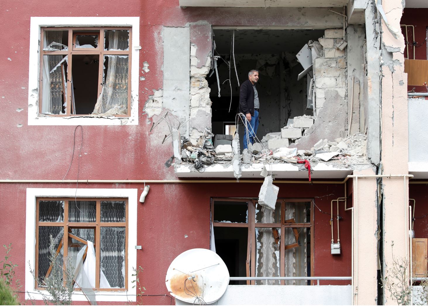 A man looks out from his damaged home after a ceasefire begins during the fighting over the breakaway region of Nagorno-Karabakh in the city of Terter