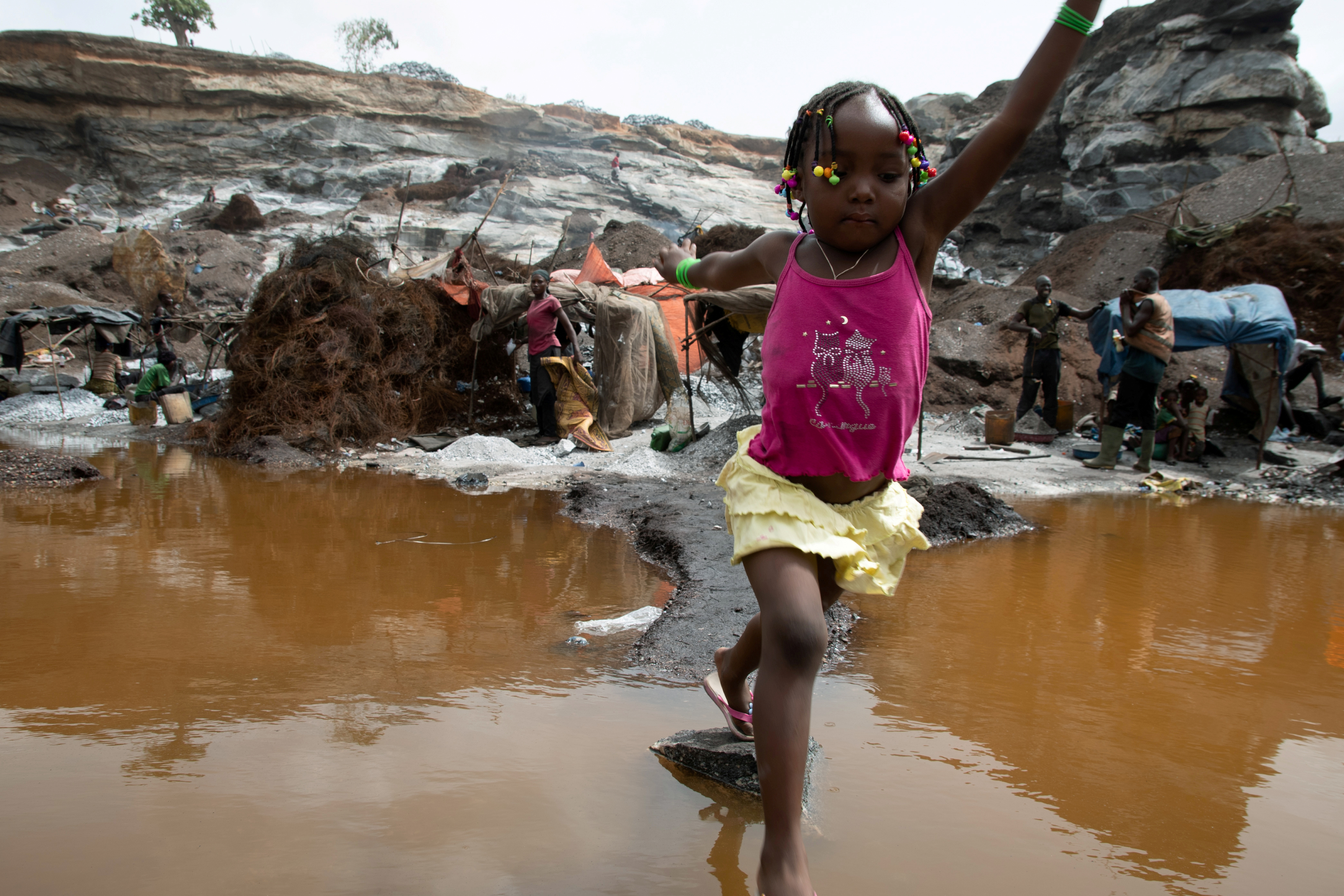 A girl jumps over a puddle in Ouagadougou, Burkina Faso