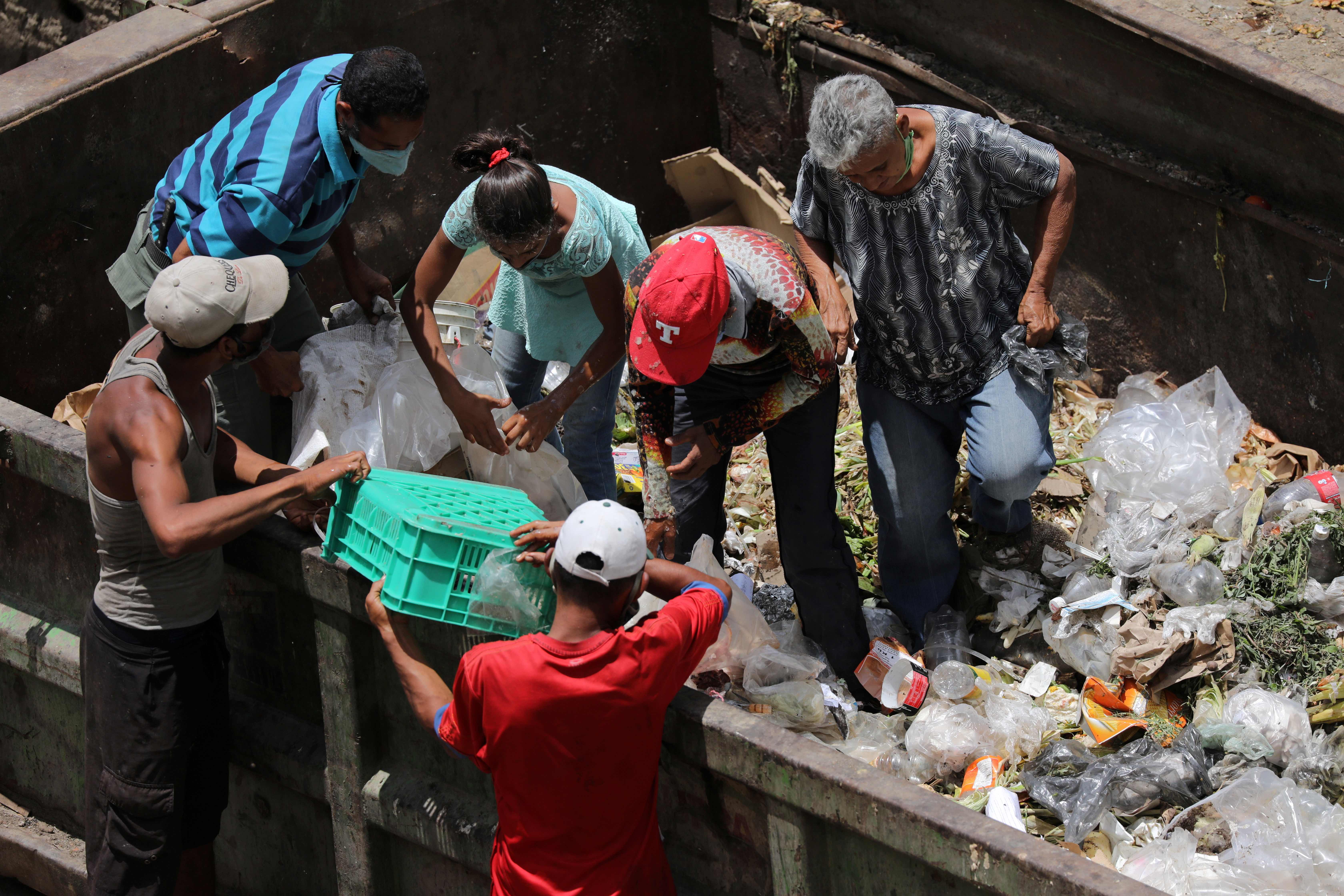 People search for food in a rubbish container during the coronavirus outbreak in Caracas, Venezuela