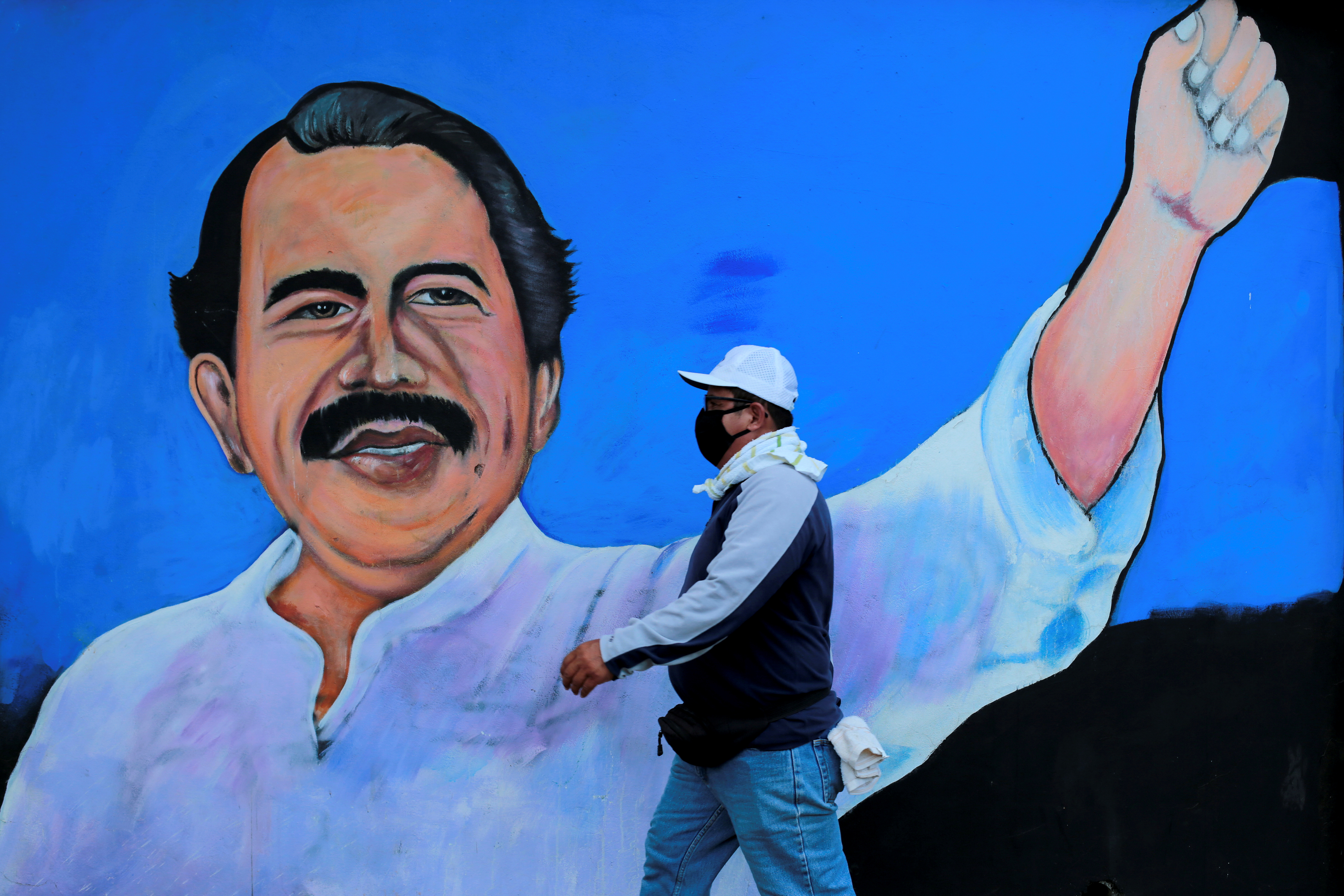 A man walks by a mural depicting Nicaraguan President Daniel Ortega, who is increasingly called a dictator, in Managua, Nicaragua on March 30