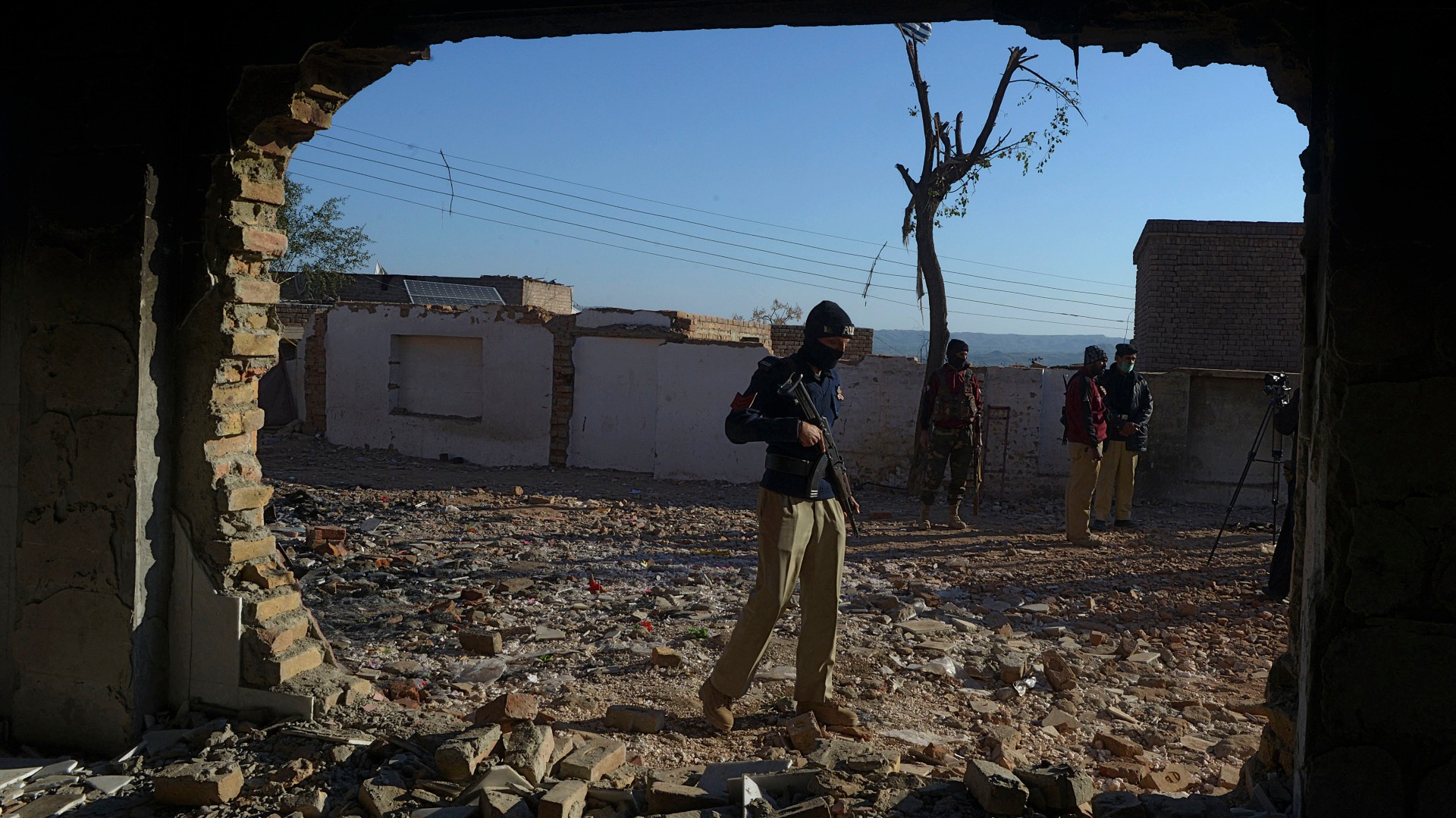 A policeman stands guard at the burned Hindu temple a day after a mob attack in a remote village in Karak district