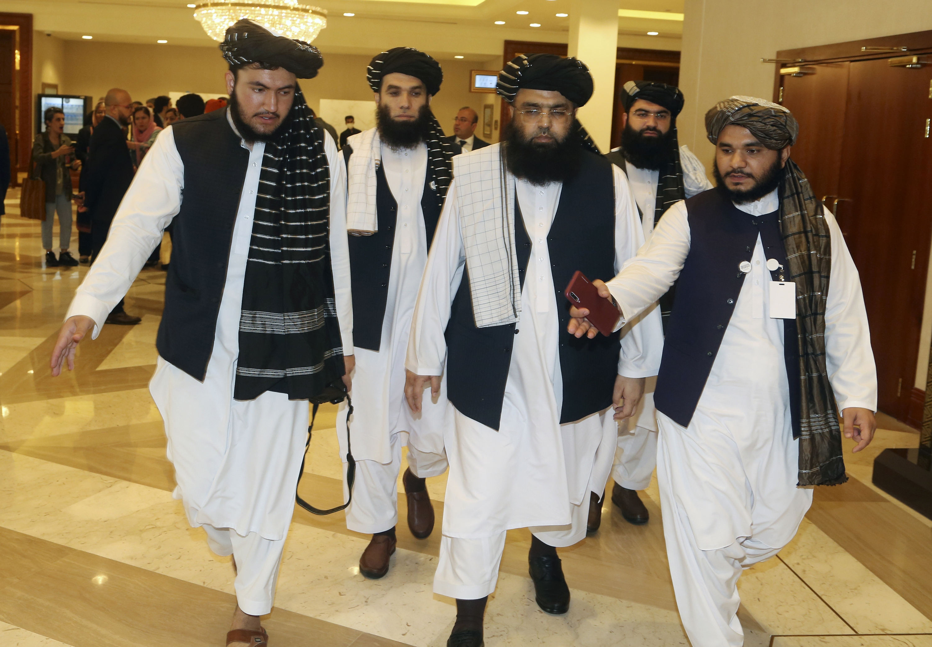 A few members of the Taliban delegation head to attend the opening session of the peace talks between the Afghan government and the Taliban in Doha on September 12, 2020 [File: AP/Hussein Sayed]