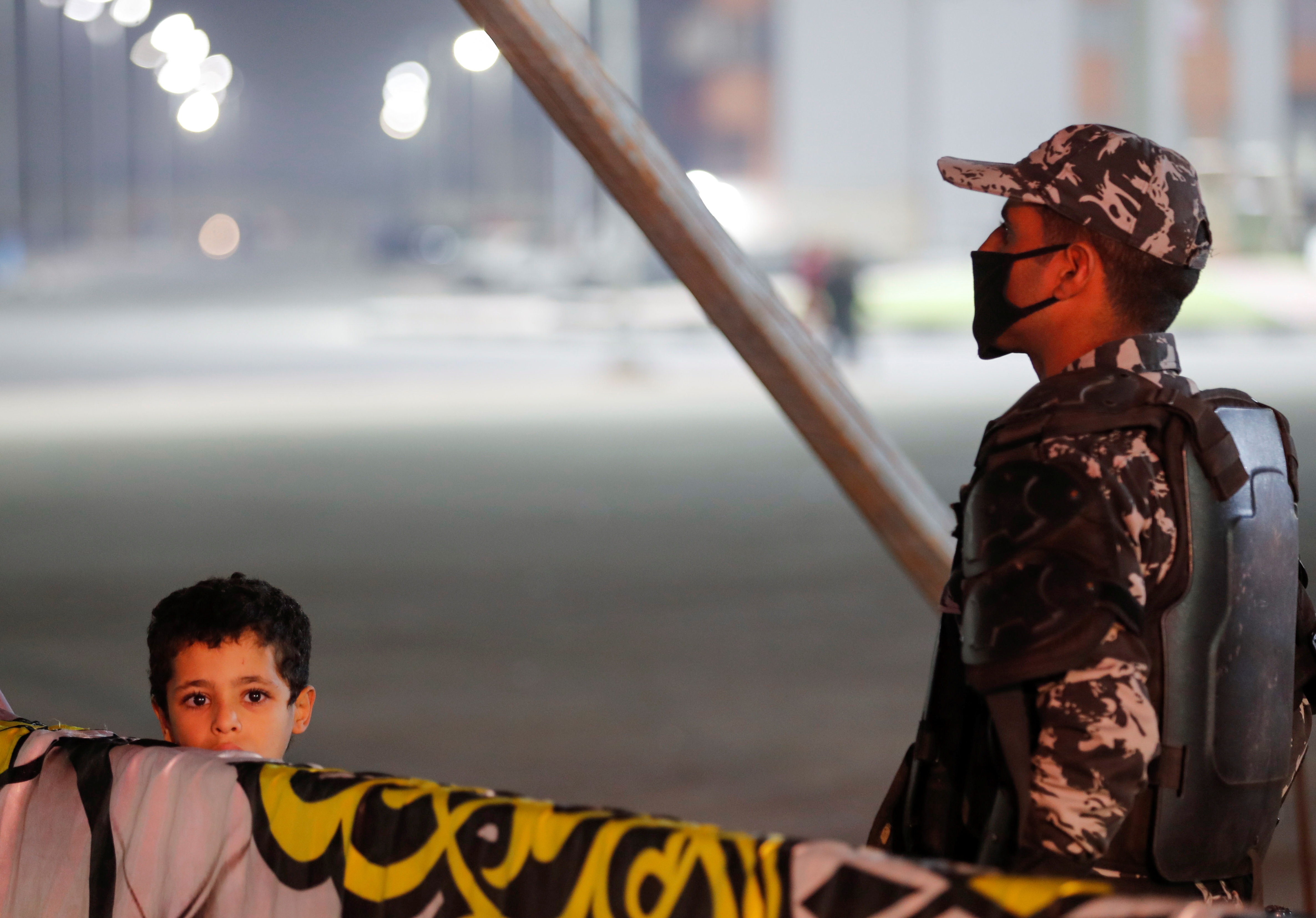 An Egyptian police officer stands guard while a child watches an Arab music troupe performance at a mobile theatre touring around the country, in Cairo, Egypt