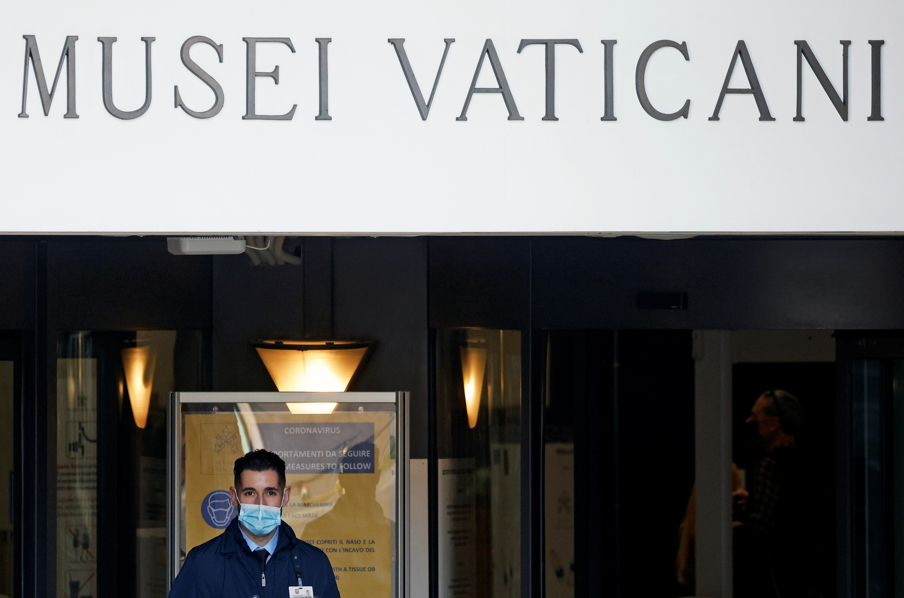 A staff member stands at the entrance of the Vatican Museums as they reopen after coronavirus restrictions were eased in Rome, Italy
