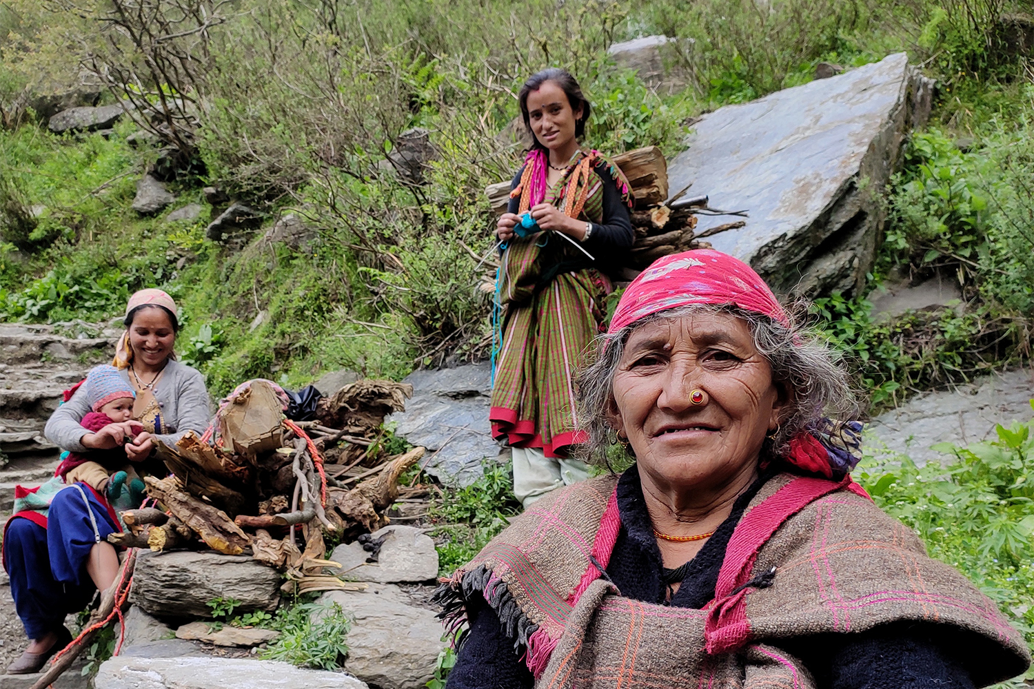 Namo Devi, front, her daughter Jiti Devi and daughter-in-law Balma Devi holding her infant son, rest while trekking to Malana village