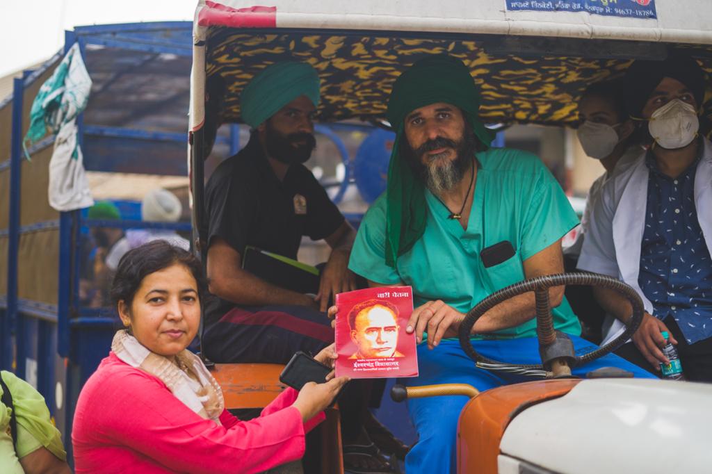 Dr Singh receives a book from one of the protesters at Tikri outside New Delhi [Courtesy: Dr Swaiman Singh]