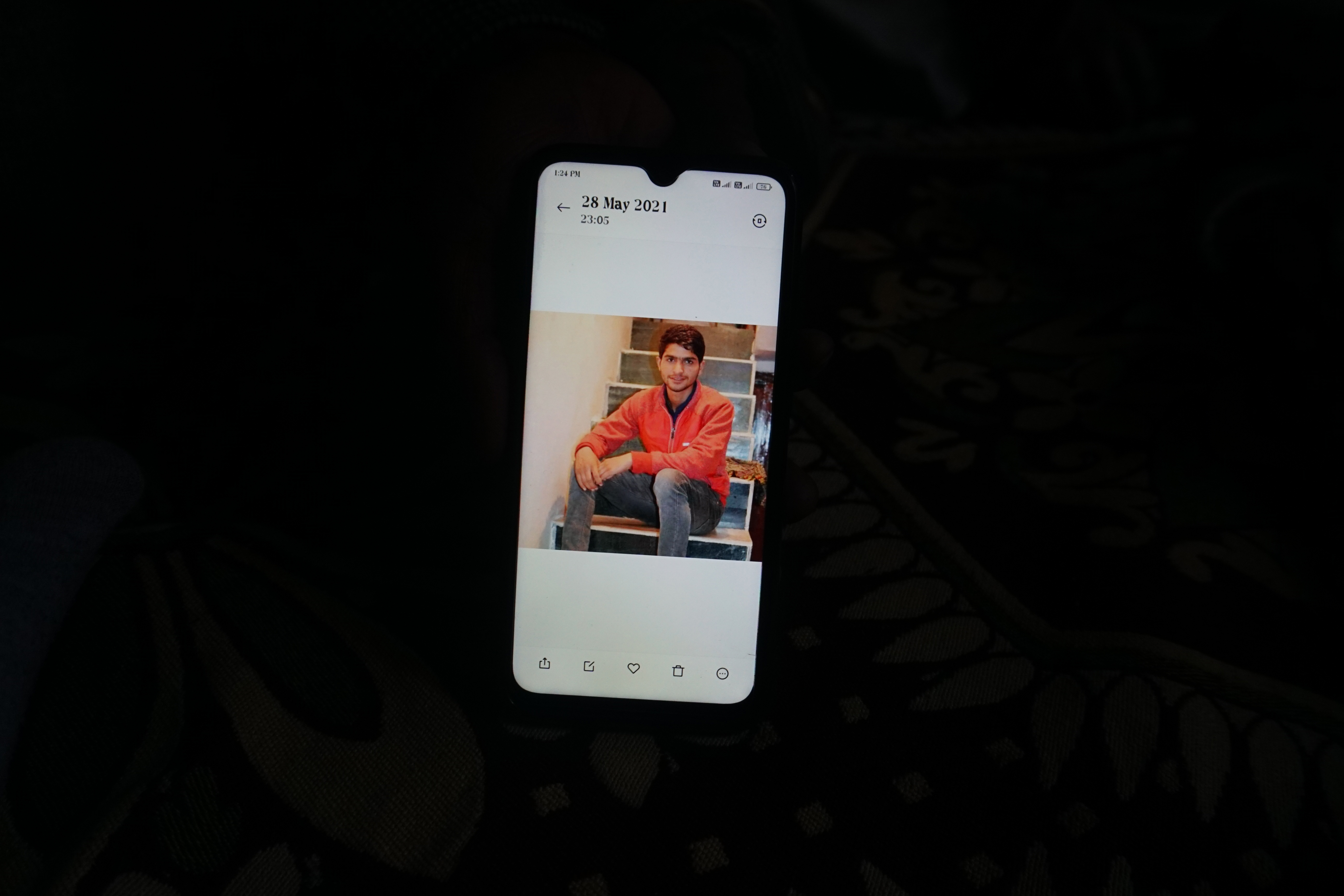 A mobile phone with a photo of Shoaib Bashir Mir